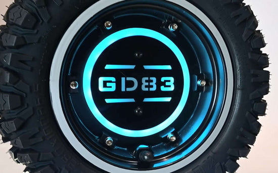 Close-up shot of a mechanic easily replacing the 11-inch off-road tire on the single-sided swing arm of a black GLIDEZONE GD83 heavy-duty electric scooter without removing the hub motor.