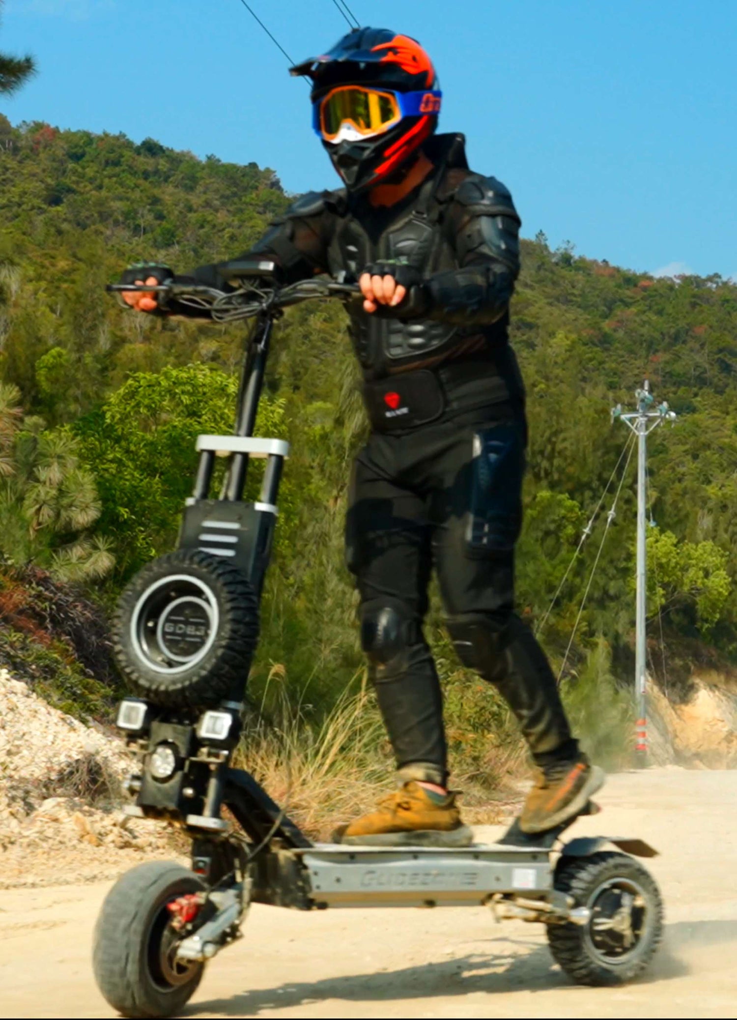 Side view of an adult male rider with a helmet speeding through a rugged off-road trail on Glidezone GD83.