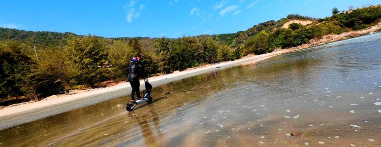 Distant landscape view of an adult rider exploring lake shallow waters on Glidezone GD83 for outdoor adventure.