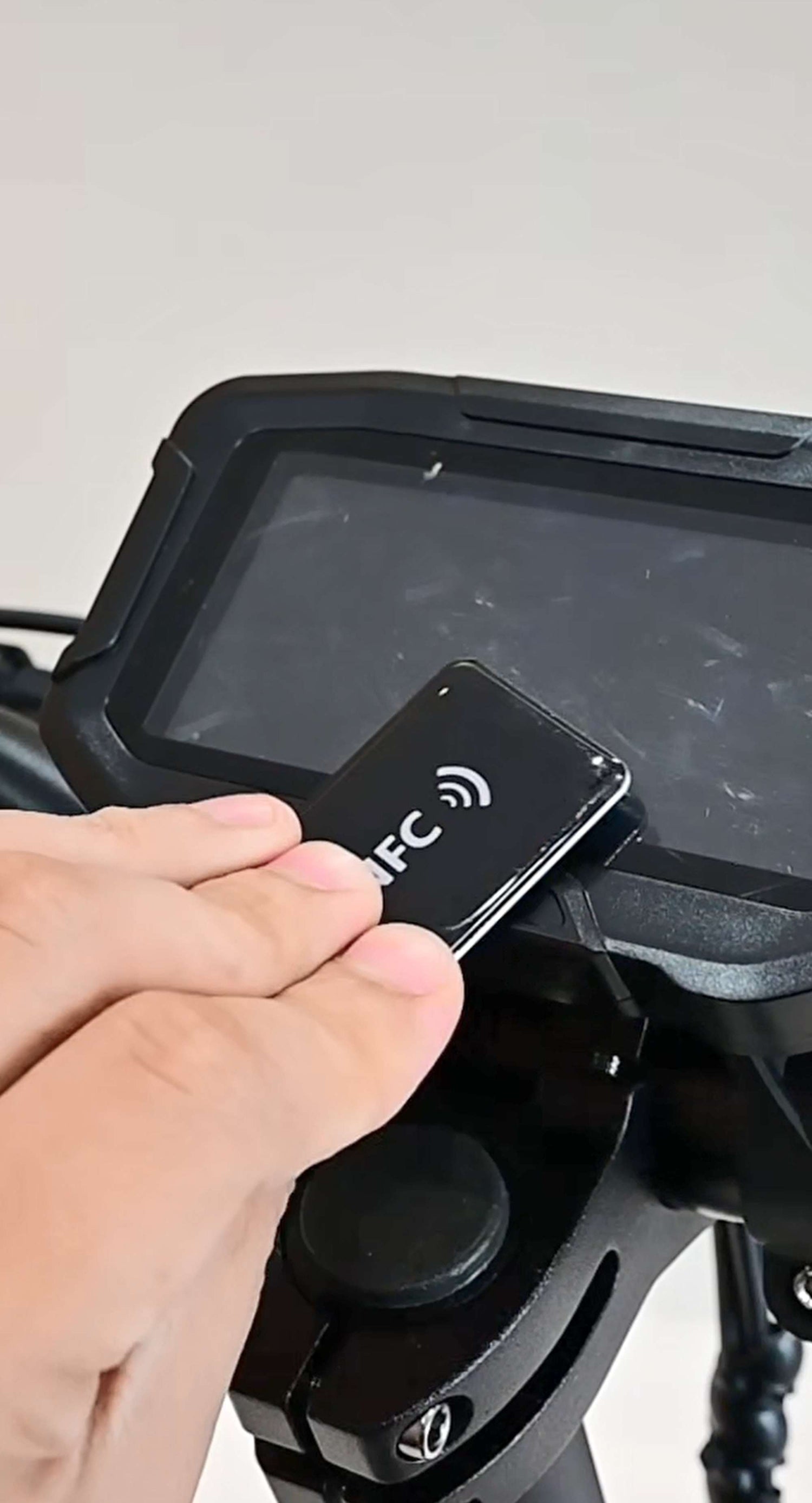 Close-up of a user unlocking the Glidezone GD83 electric scooter with an NFC card swipe ignition.