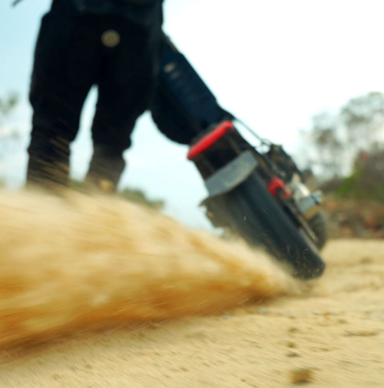 Action shot of Glidezone GD83 rear wheel spinning and throwing up sand dust, showing its 5600W power burst.