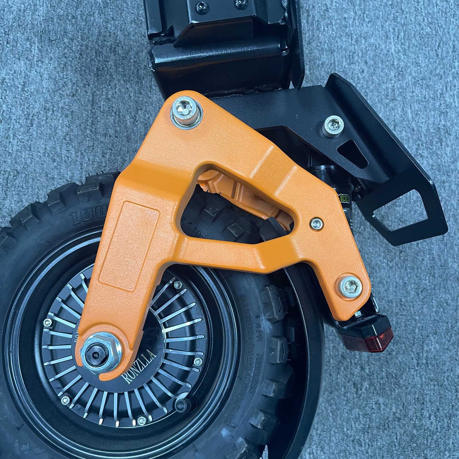 Orange left rear swing arm mounted on a Ronzlla RZ2 electric scooter hub motor wheel
