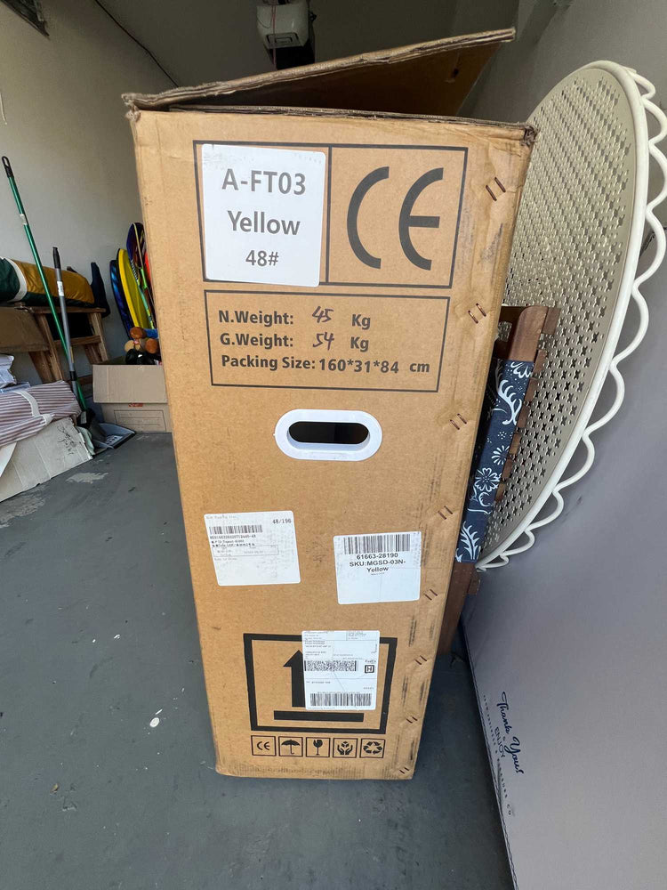 A large cardboard shipping box for a wholesale used electric bike in a US warehouse, showing technical specifications like a net weight of forty-five kilograms, gross weight of fifty-four kilograms, package size dimensions, and CE safety certification marks.